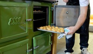 Tray of food being placed into the oven of a green esse range cooker