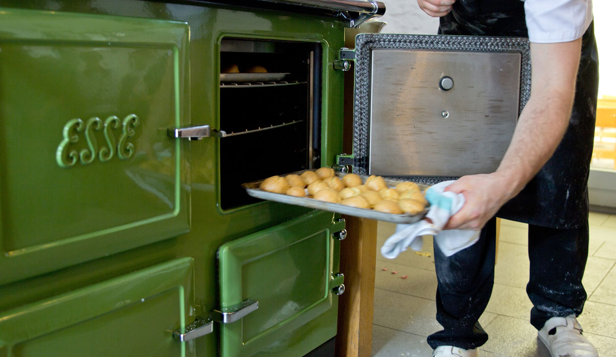 Tray of food being placed into the oven of a green esse range cooker